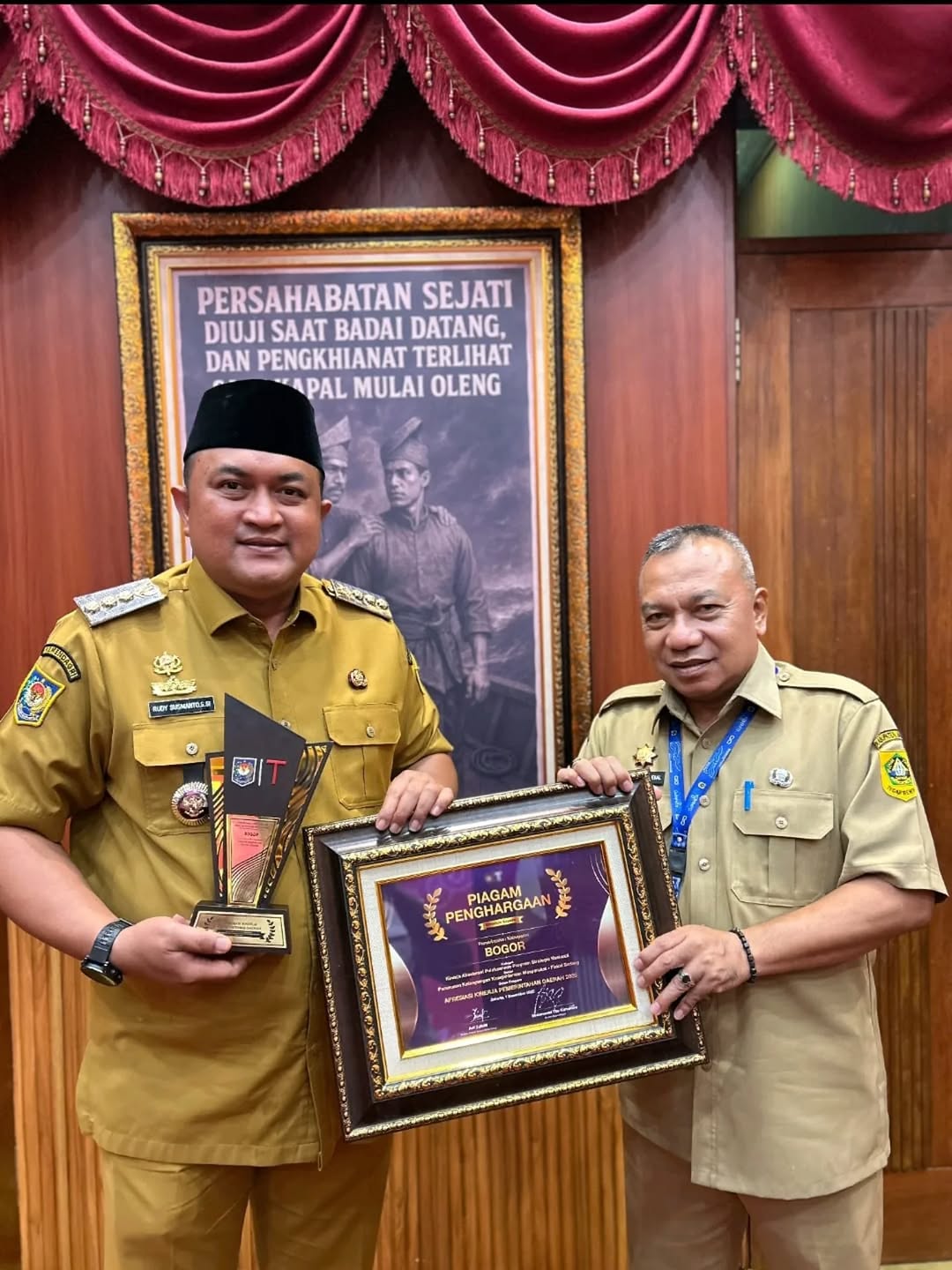 Menyerahkan dua piagam penghargaan kepada Bupati Bogor, Rudy Susmanto.